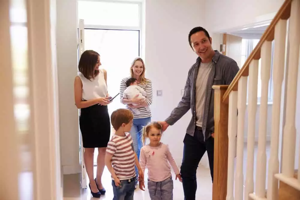 Realtor Showing Young Family Around Property For Sale